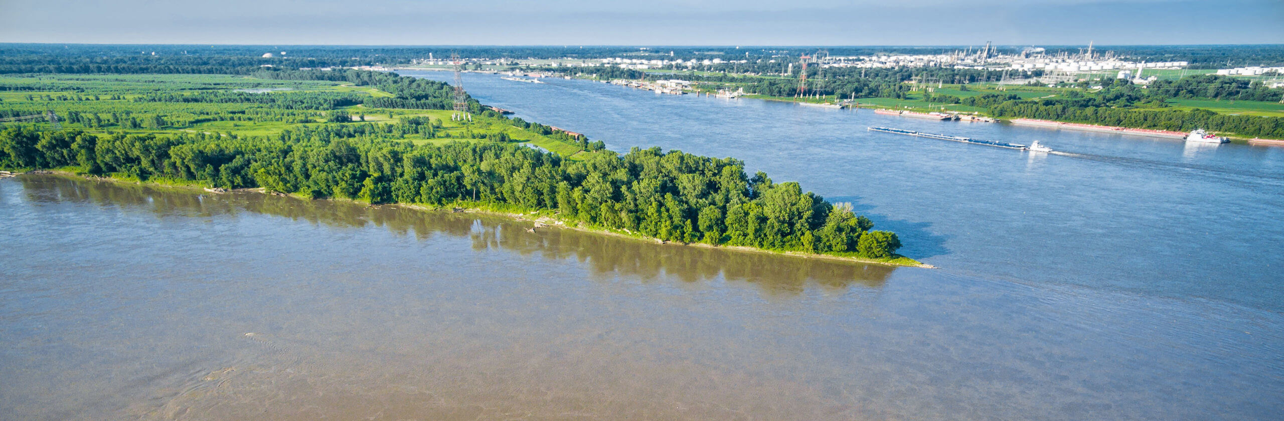 Photo of the confluence of the Mississippi River and Missouri Rivers. Two rivers merging into one with a pointy land mass in between.